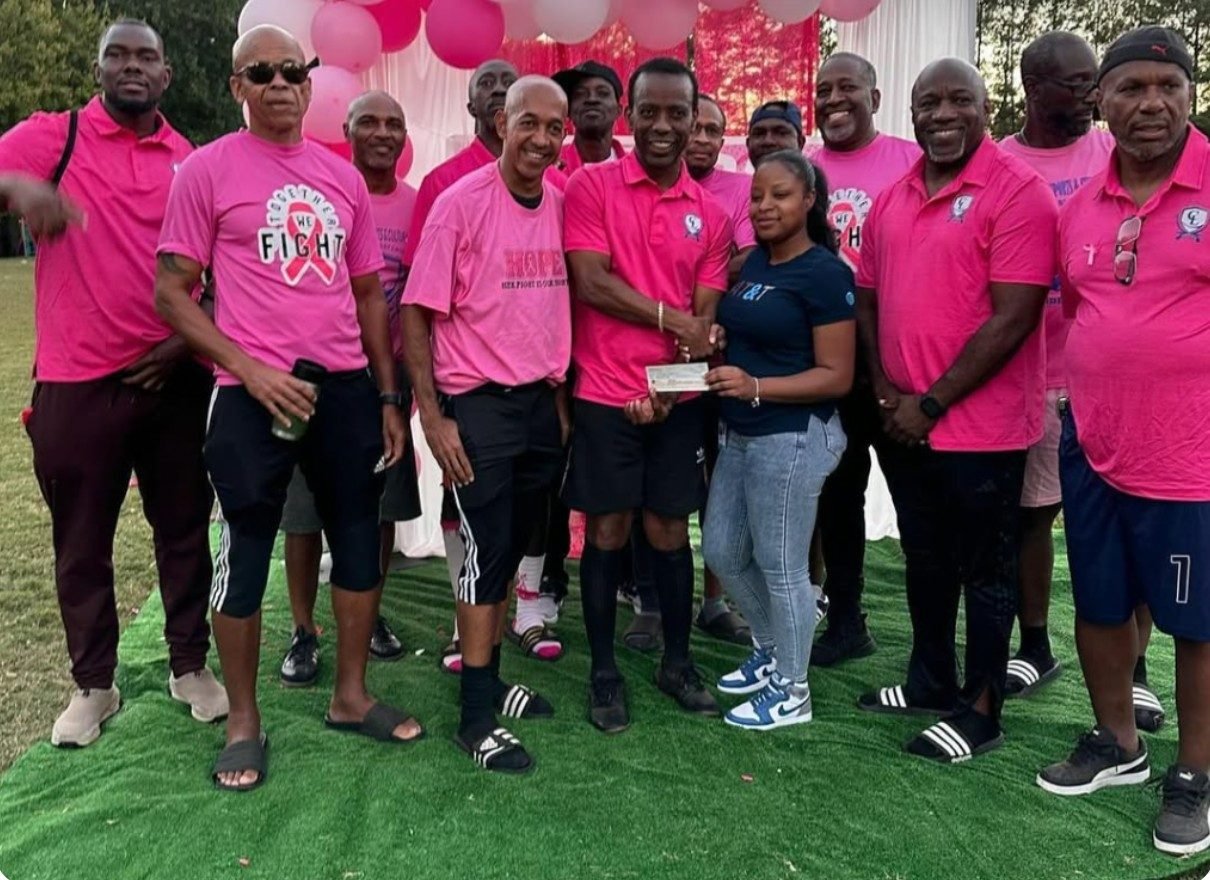 Cariblanta members in pink presenting a donation cheque at the Breast Cancer Awareness Tournament